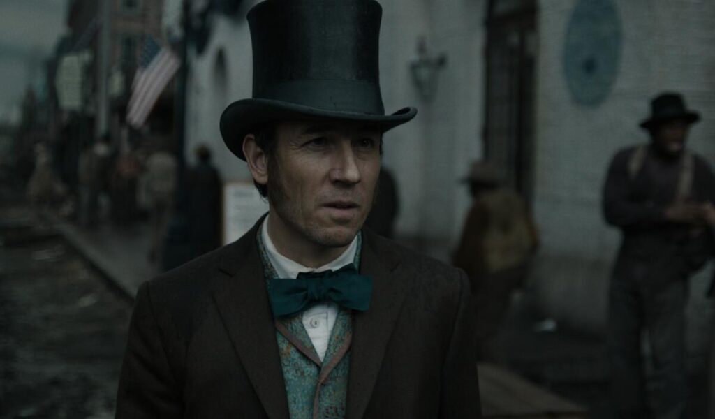 Tobias Menzies, in tophat and bowtie, in "Manhunt."