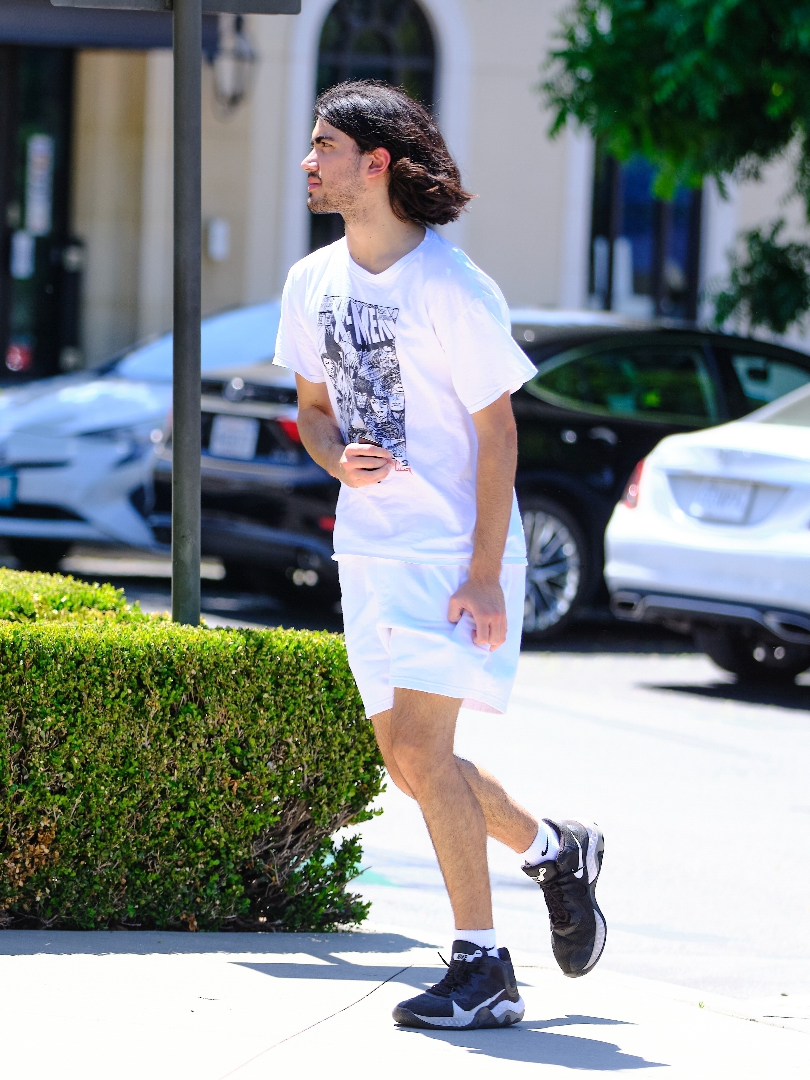 He wore white shorts, a white X-Men T-shirt, and Nike sneakers