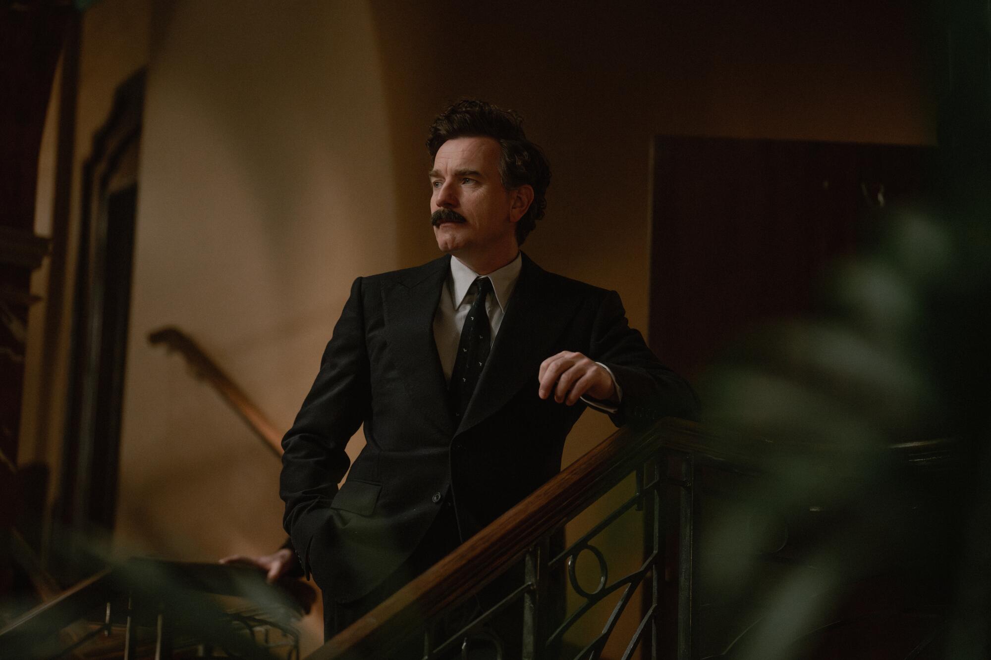 A mustachioed Russian count stands on the stairs in an old-school hotel in "A Gentleman in Moscow."