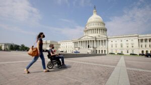 A woman with a man in a wheelchair near the U.S. Capitol building in "For Love & Life: No Ordinary Campaign."