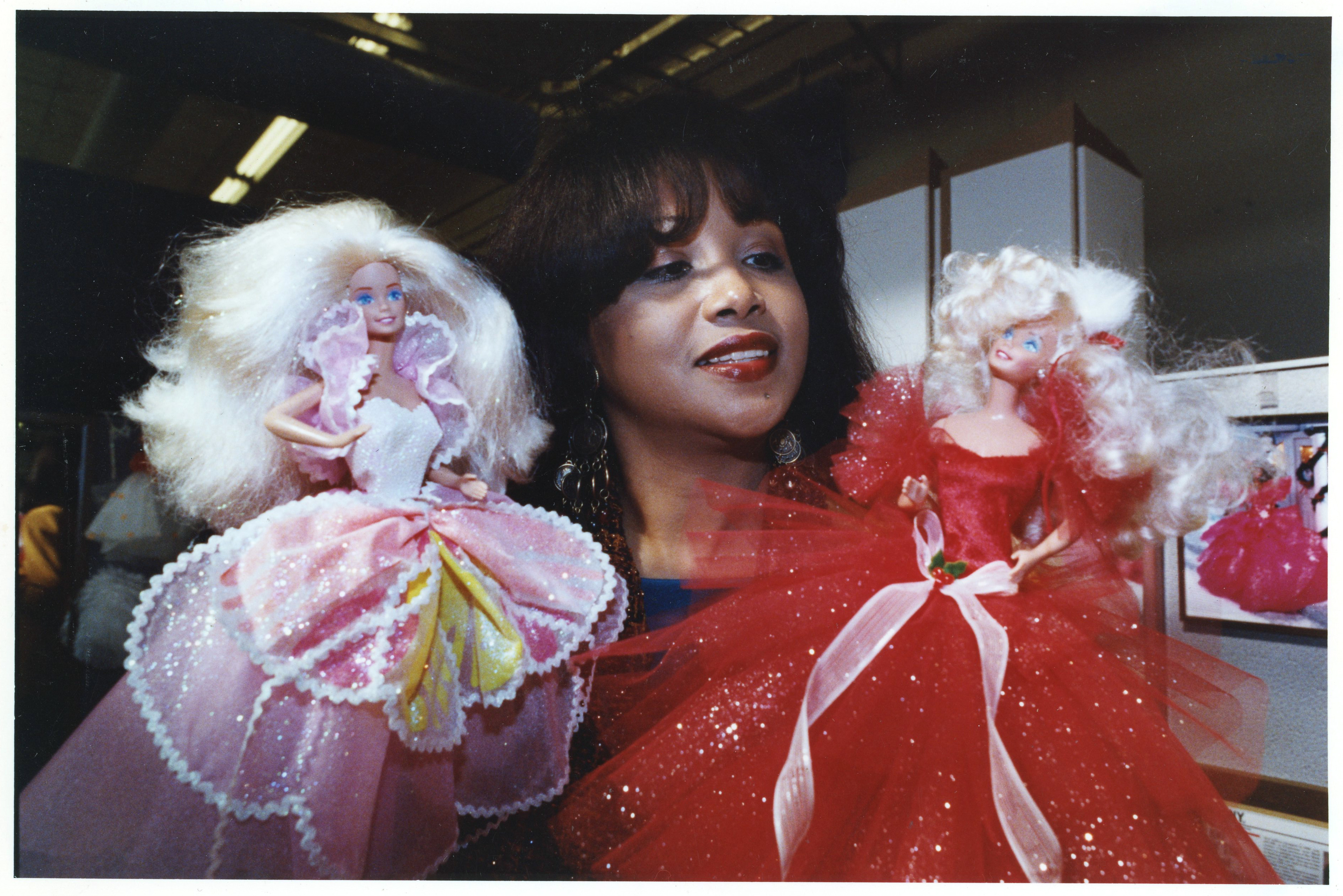Louvenia 'Kitty' Black Perkins shows off two of her shimmering creations for Barbie dolls at the Mattel offices in El Segundo, California, on January 29, 1991