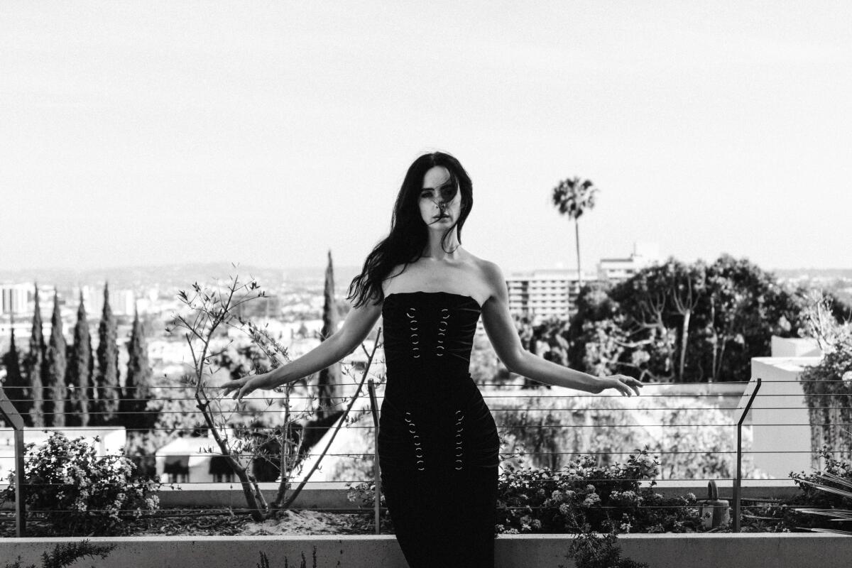 a black and white portrait of a woman with the city in the background