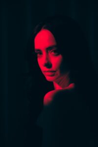 A woman bathed in red light.