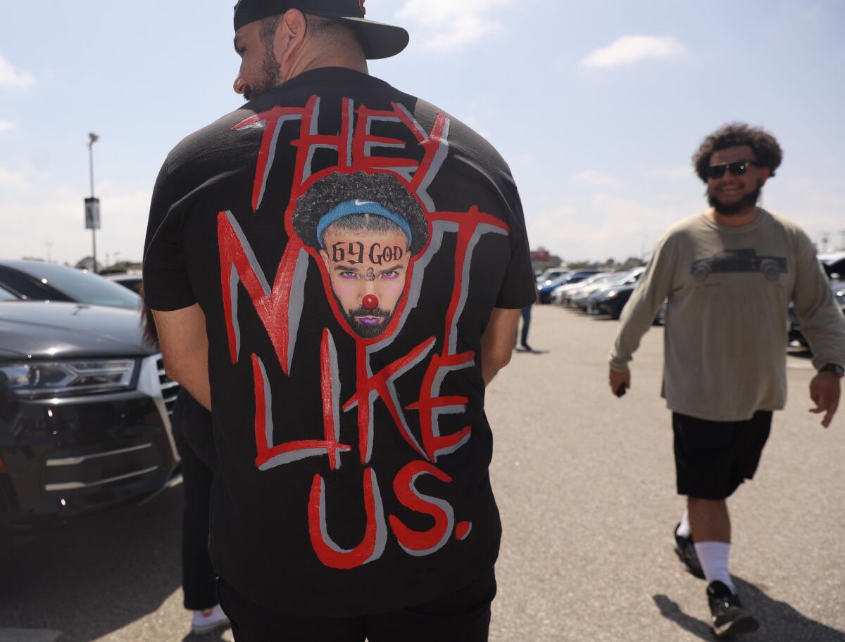 Man in "They Not Like Us" shirt clowning Drake