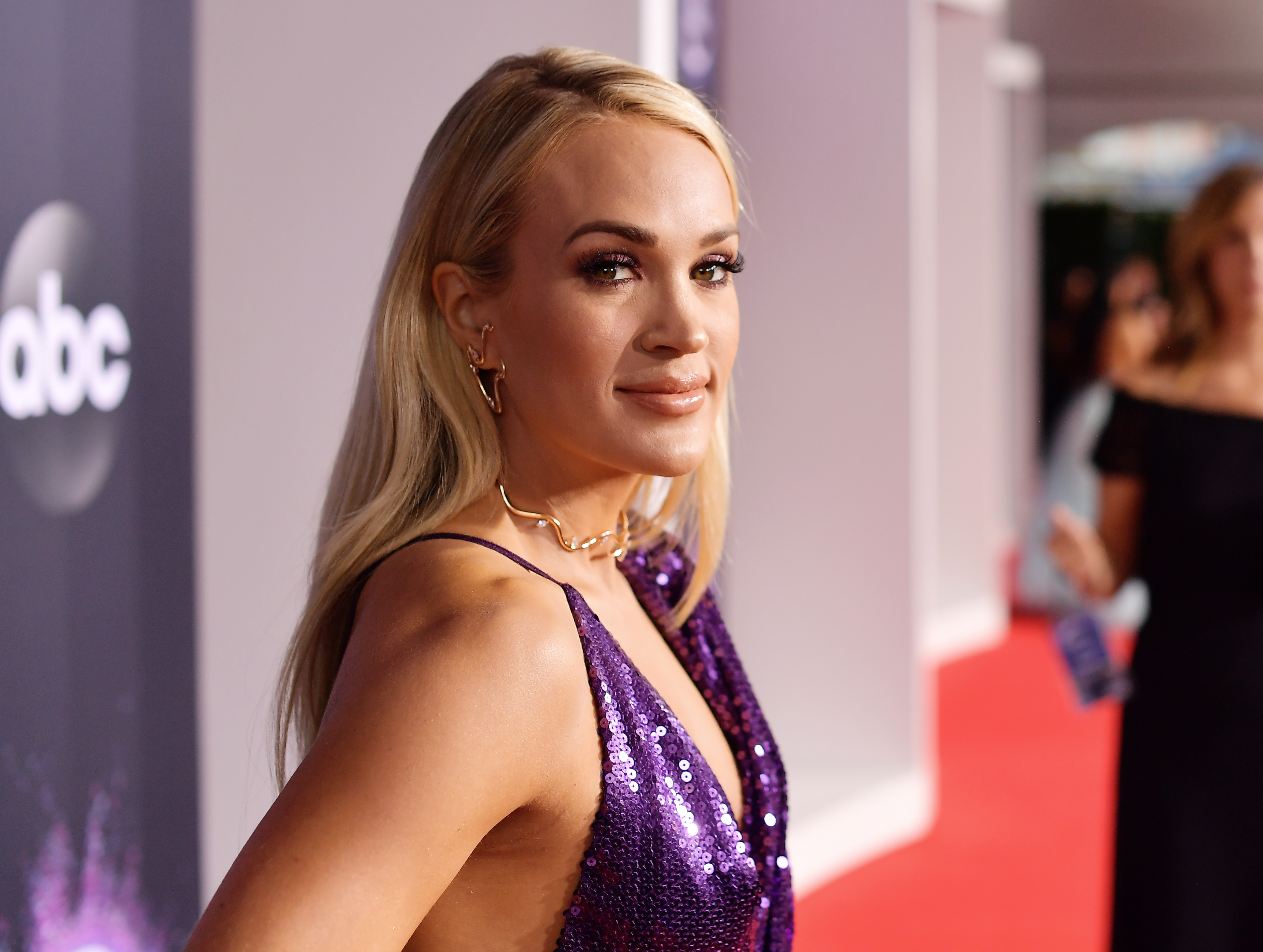 Carrie Underwood strutted the red carpet in a purple sequined gown for the American Music Awards