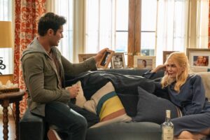 Zac Efron as Chris Cole holds a picture frame up and look as Nicole Kidman as Brooke Harwood looks at him.