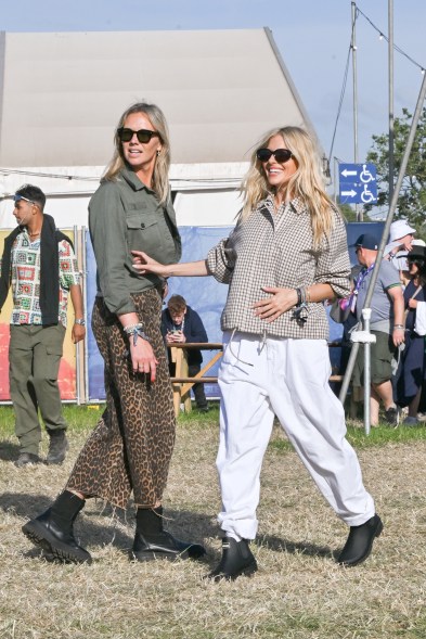 Sienna Miller arriving at the Glastonbury Festival, wearing Barbour, standing in a field with another woman on June 28, 2024.