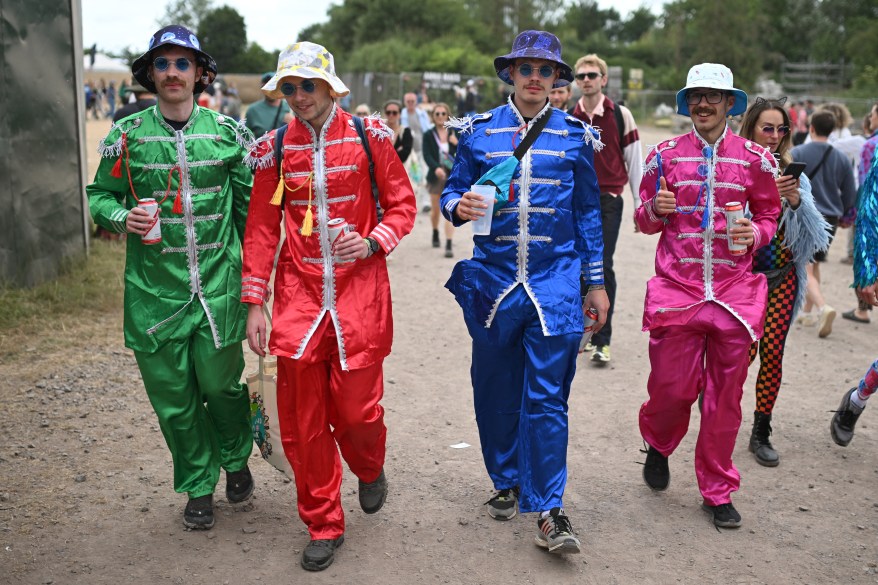 Festivalgoers dressed as The Beatles attend.