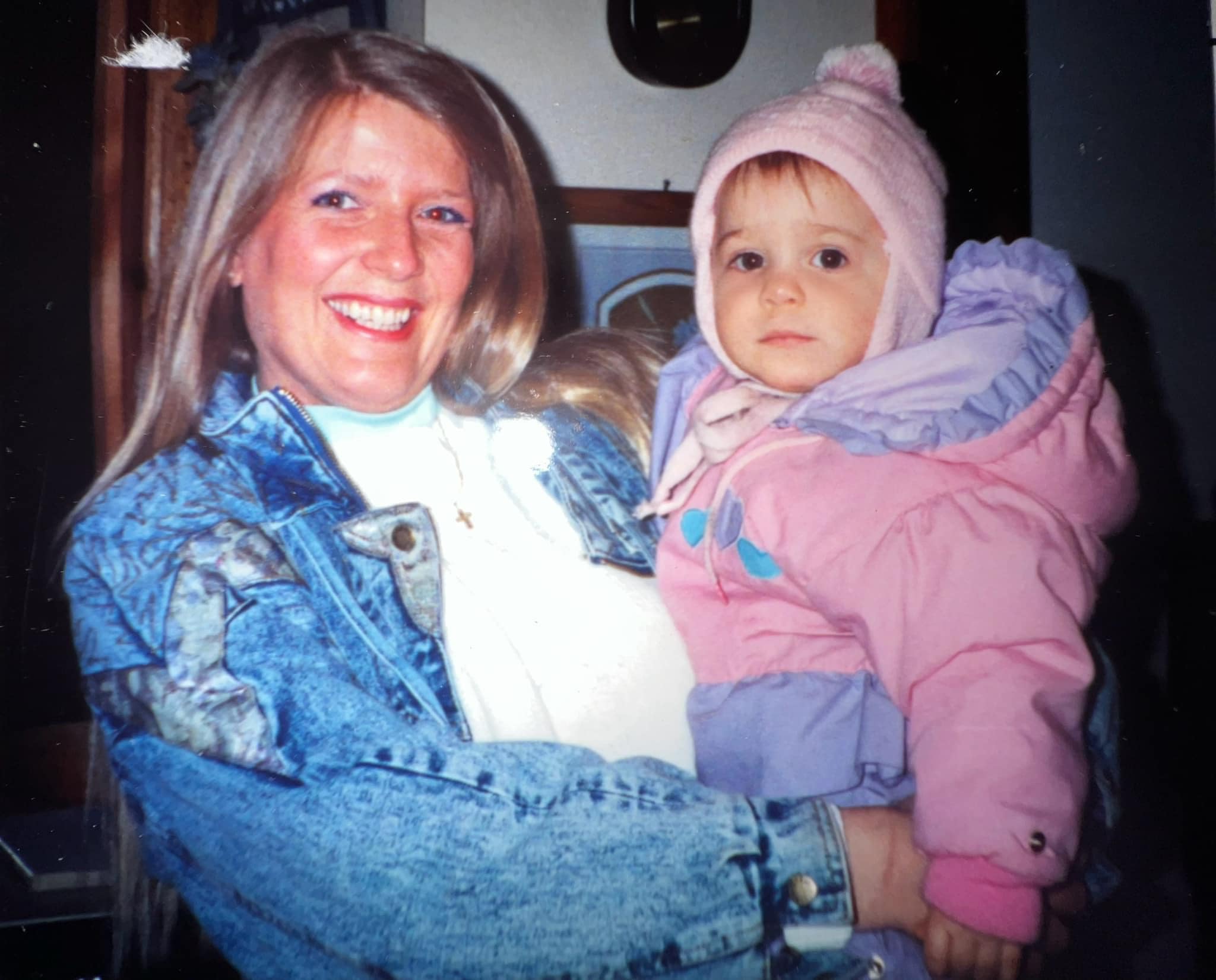 The post features Lizzy in a pink and lilac snowsuit being held by her mother