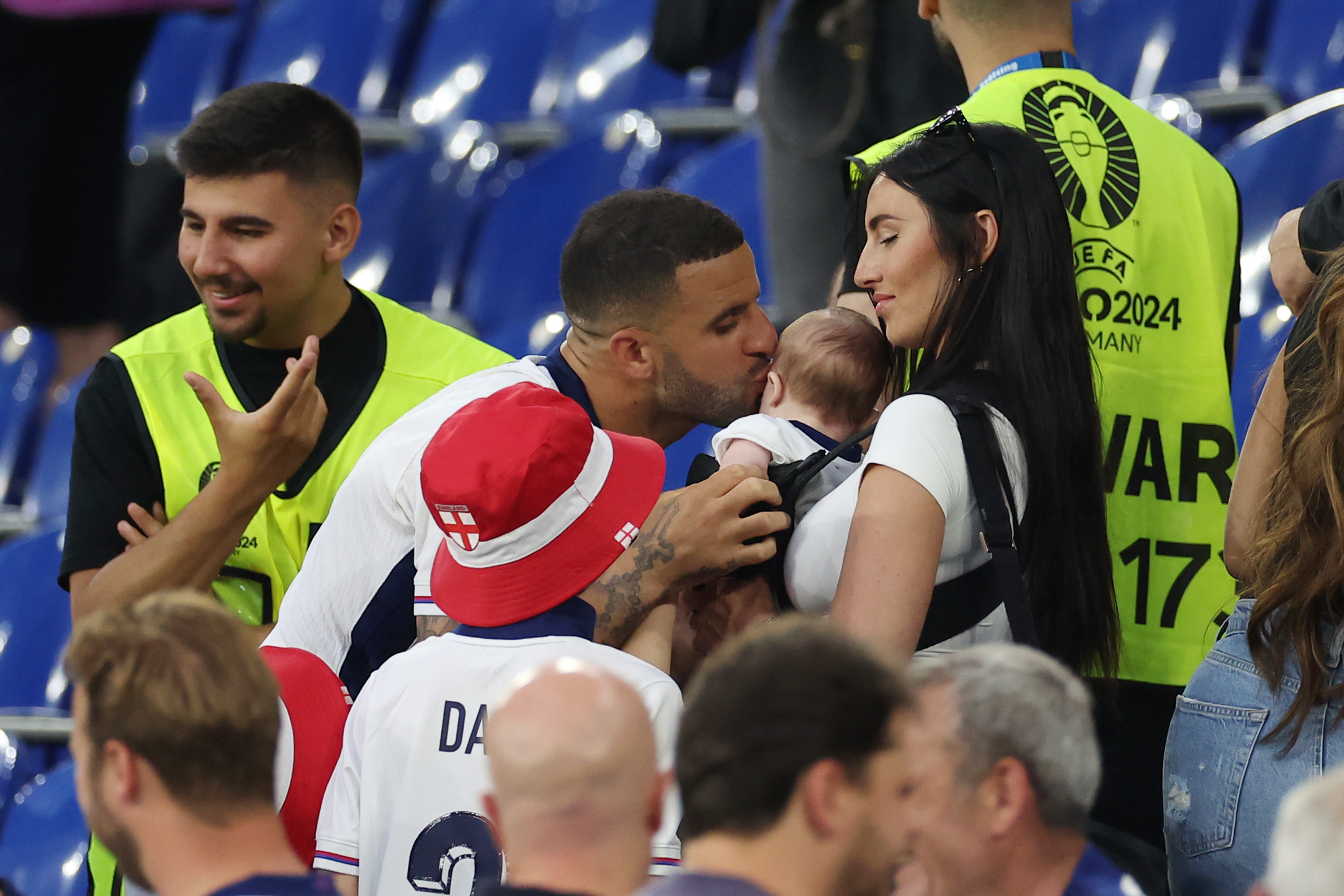 Kyle Walker of England kisses his child with his wife Annie Kilner after the match