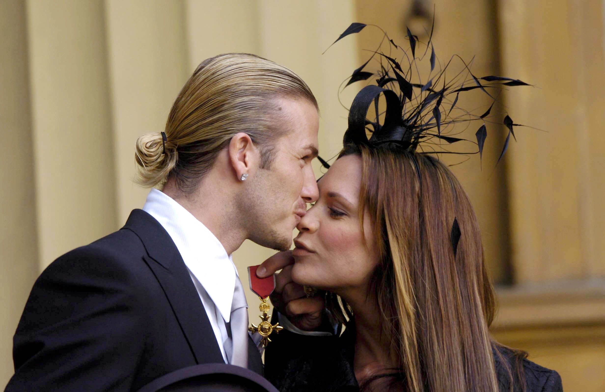 David plants a gentle kiss on Victoria’s nose after being awarded an OBE at Buckingham Palace in 2003