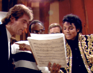 Huey Lewis and Michael Jackson at the recording of 'We Are the World.' Quincy Jones can be seen behind the sheet music.