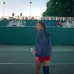 Zendaya walks away from the camera on a tennis court in Challengers