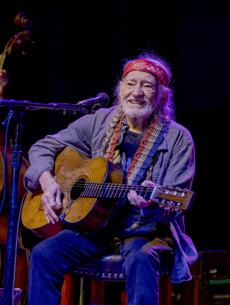 Willie Nelson playing guitar and singing at a concert in Pinewood Performing Arts, Lincoln, Nebraska on May 15, 2024