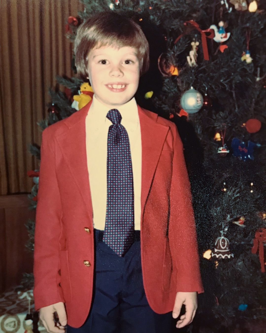 Above, a young Ryan Seacrest smiles in front of a Christmas tree