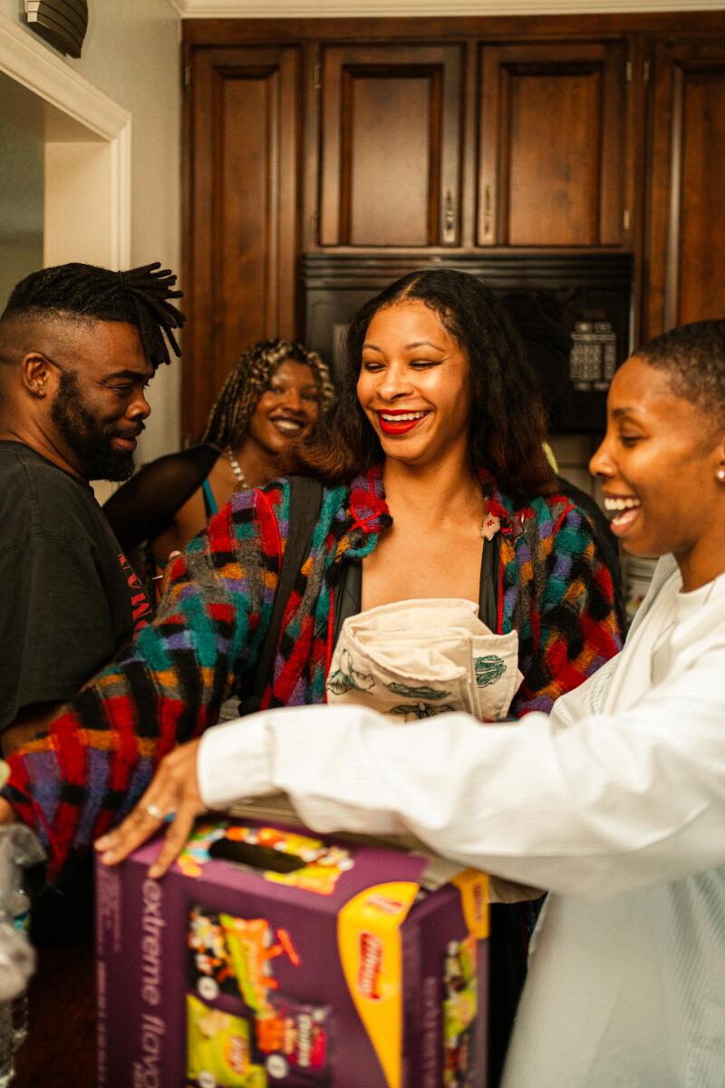 "Black House" attendees socialize in the kitchen over slices of pizza and homemade pound cake.