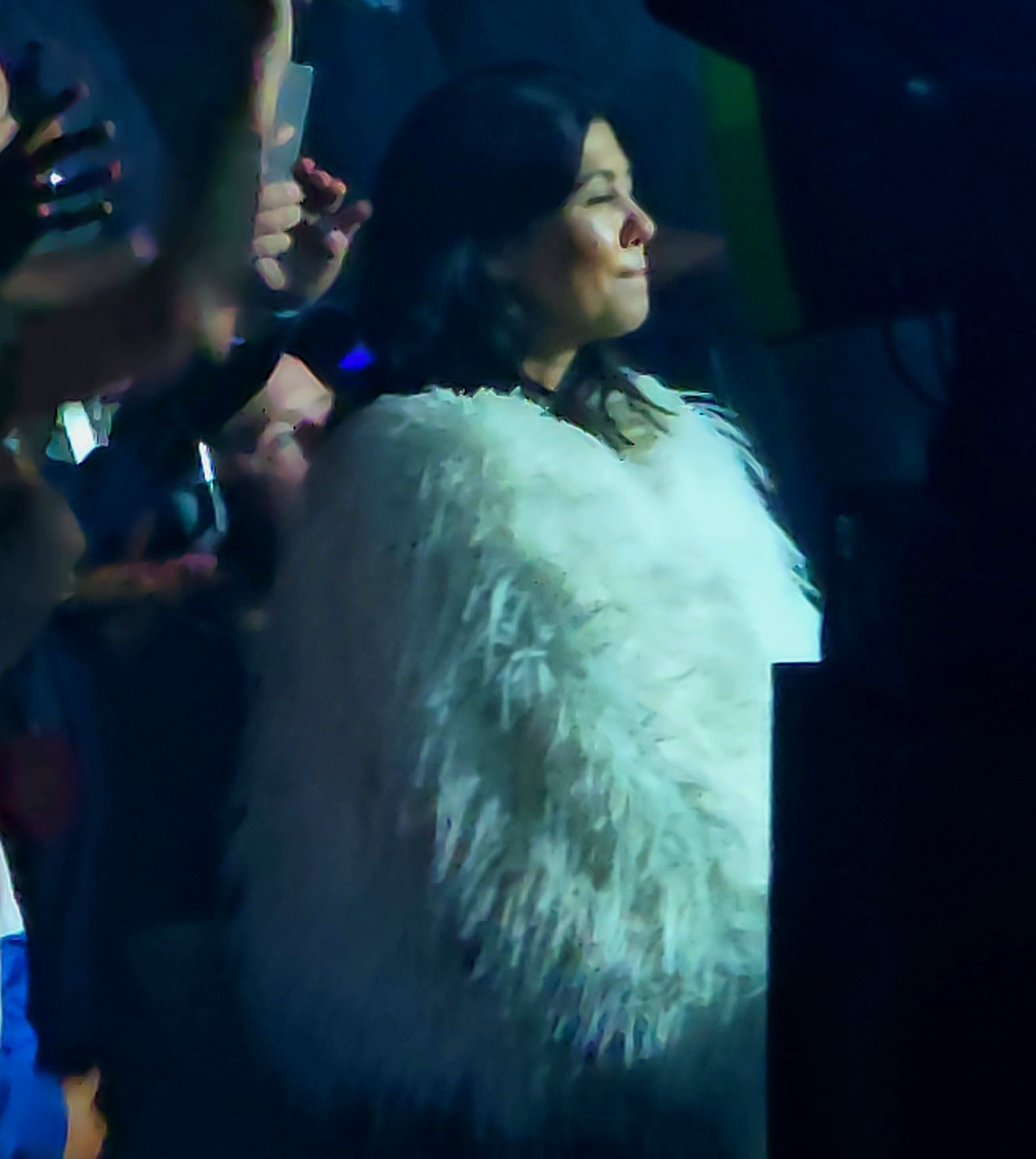 Kourtney Kardashian donning a white fur coat at her husband Travis Barker's concert