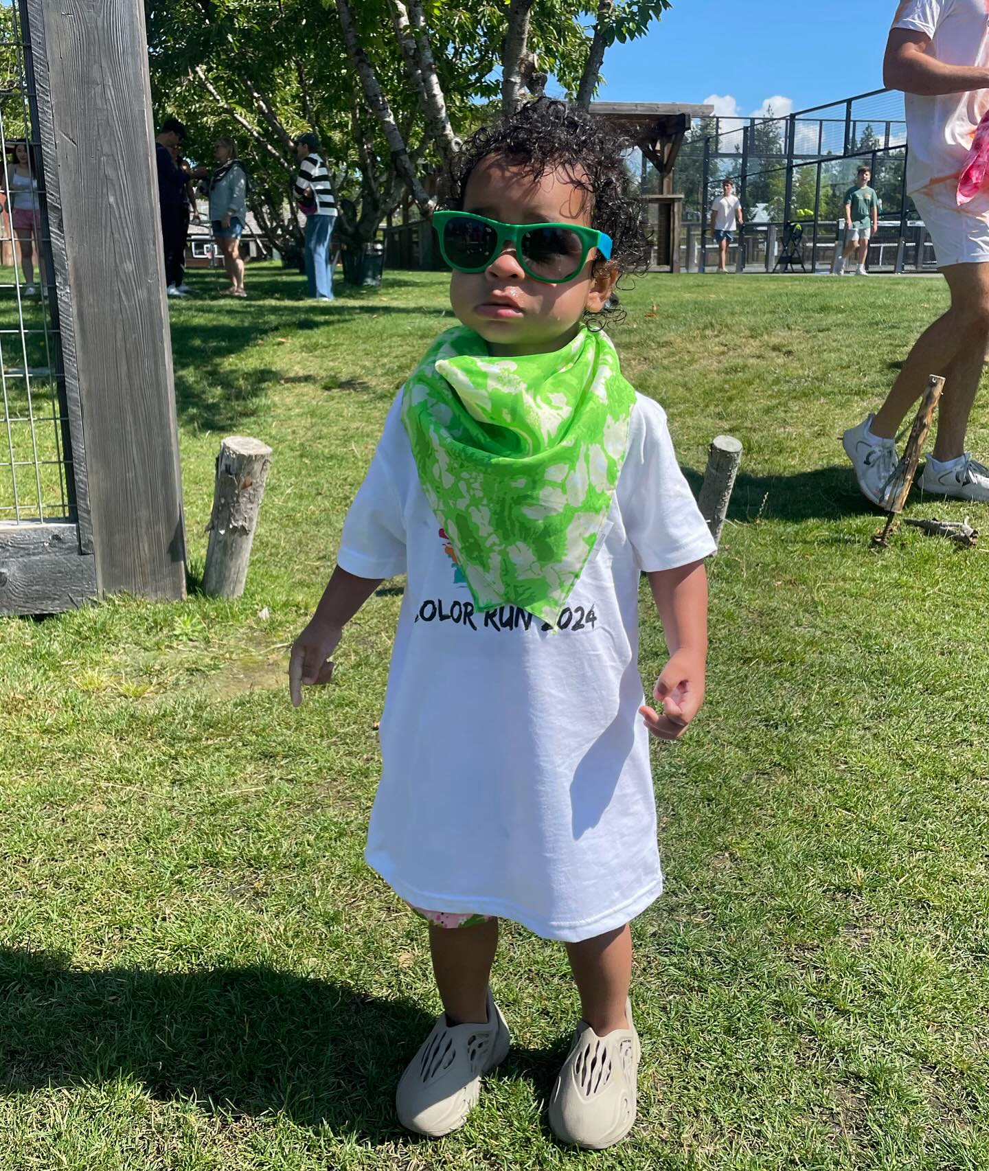 Khloe Kardashian's son Tatum Thompson wearing green sunglasses and a neon green bandana