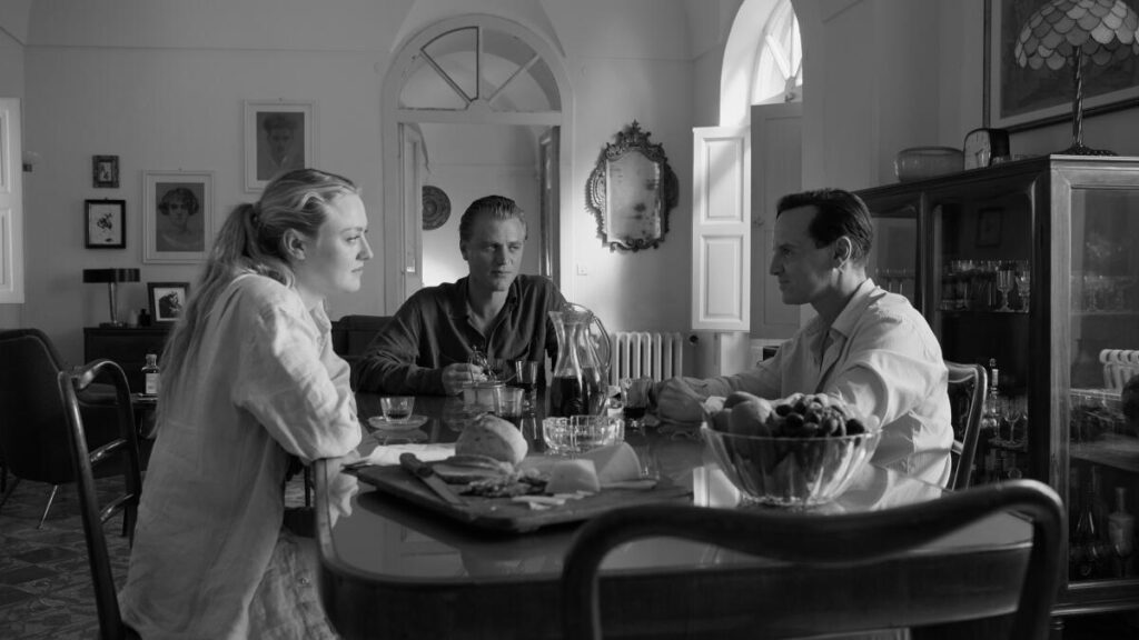 A woman and two men sitting at a dining table.