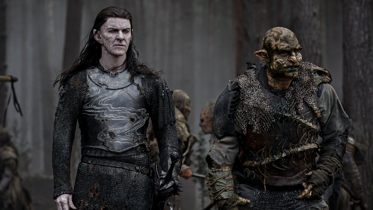 Adar walks beside an orc in a dark forest in season 2 of The Rings of Power