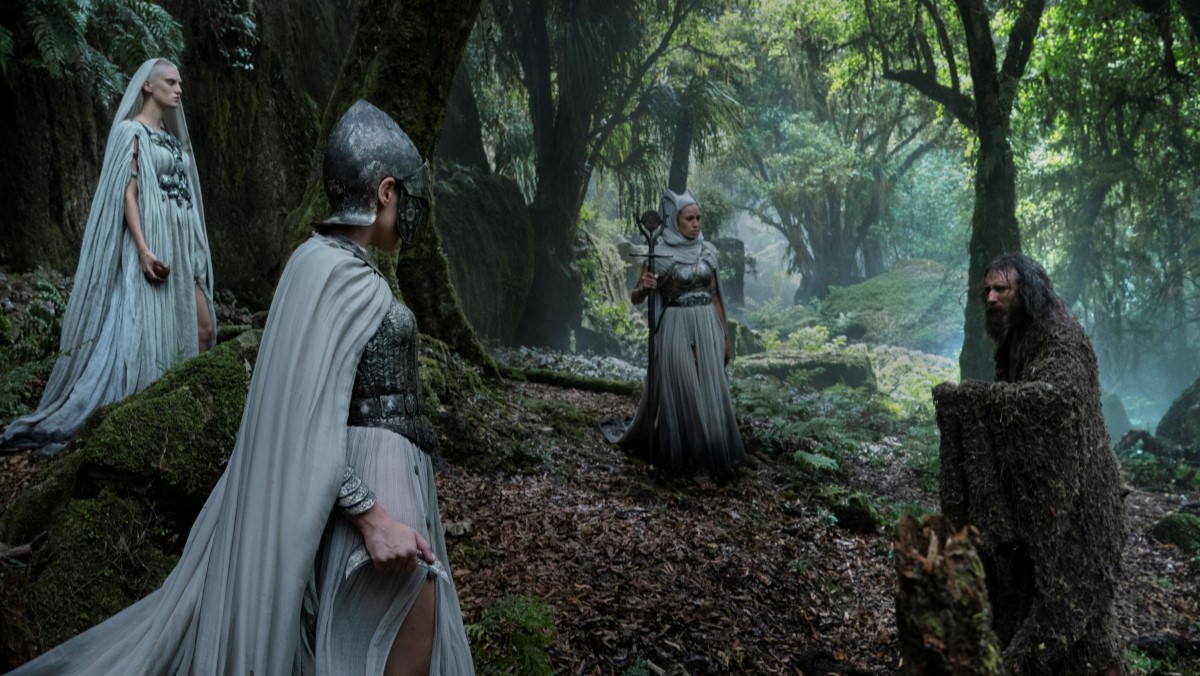 The Stranger and three white cloaked figures meet in a forest in The Rings of Power