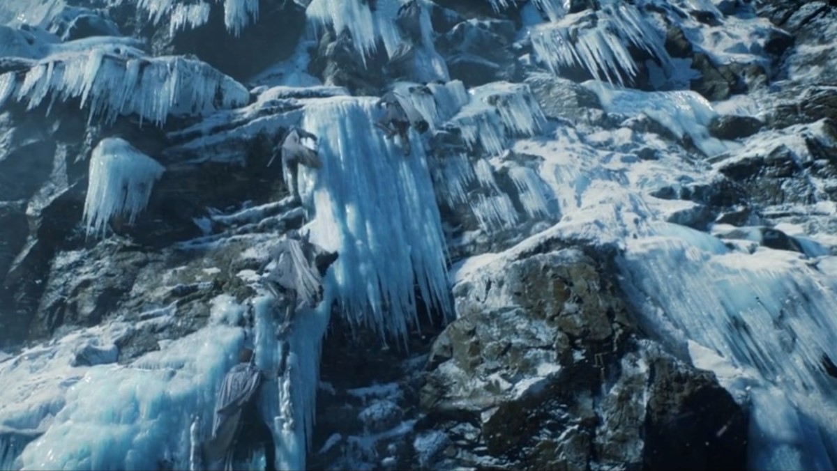 An icy cliff with elves climbing up it in The Rings of Power