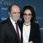 Comedian Bob Newhart smiling next to his wife, Ginnie Newhart