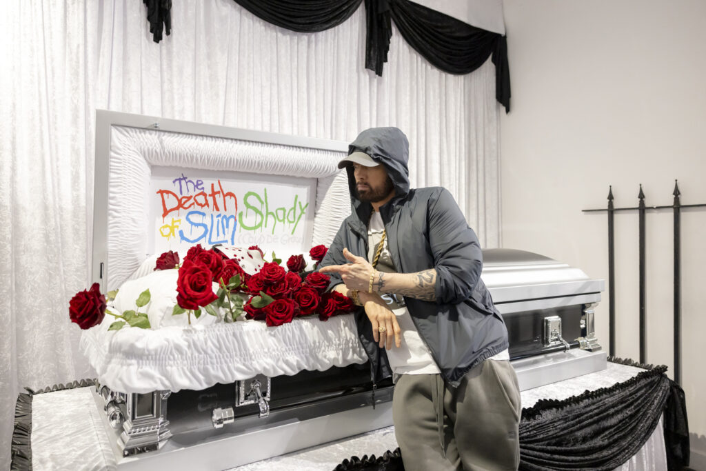 Eminem attends The Death of Slim Shady pop-up in London, above an open coffin with the 'corpse' of his alter ego Slim Shady was on display