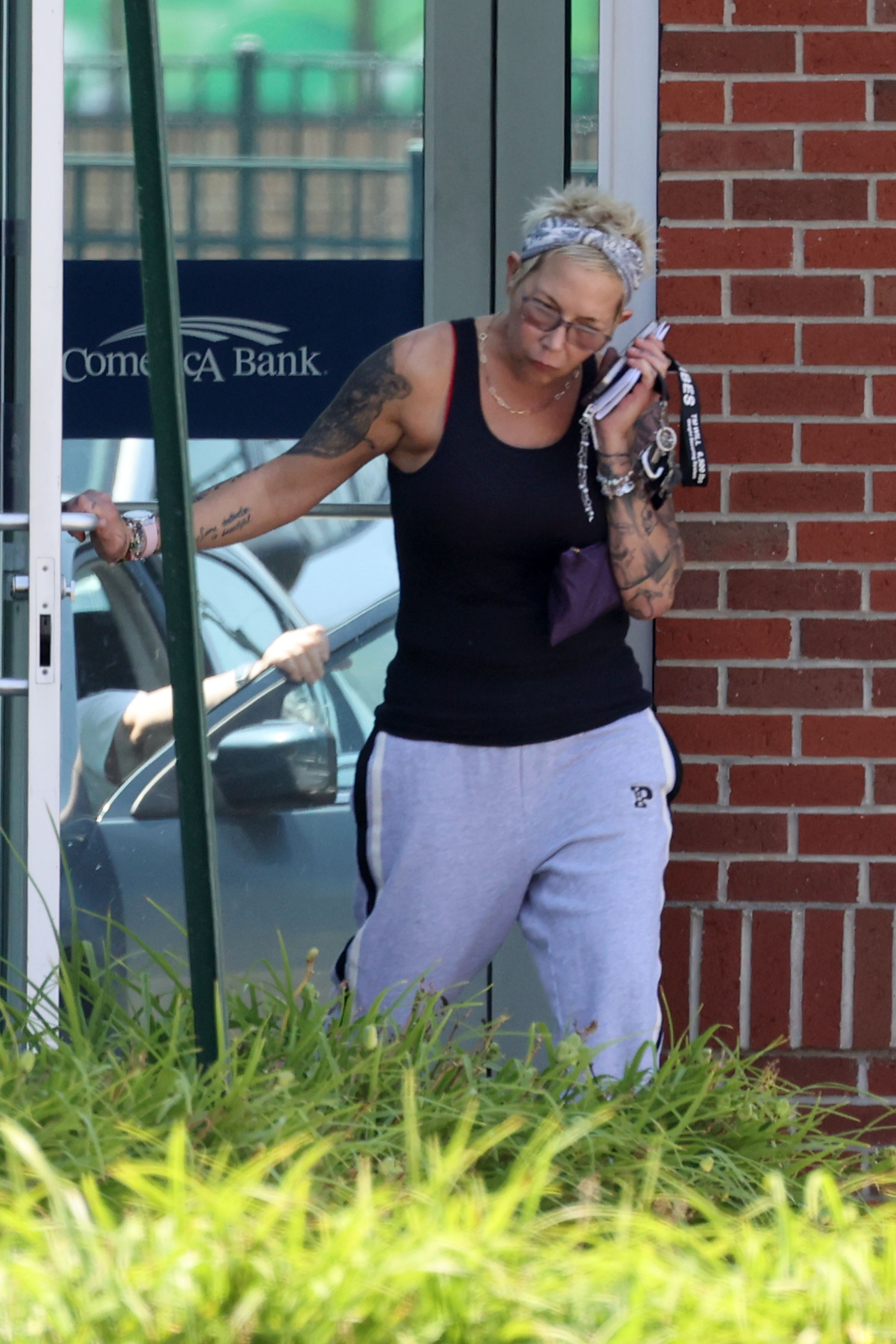 Tattooed Kim Mathers was seen holding her phone to her ear as she left the bank