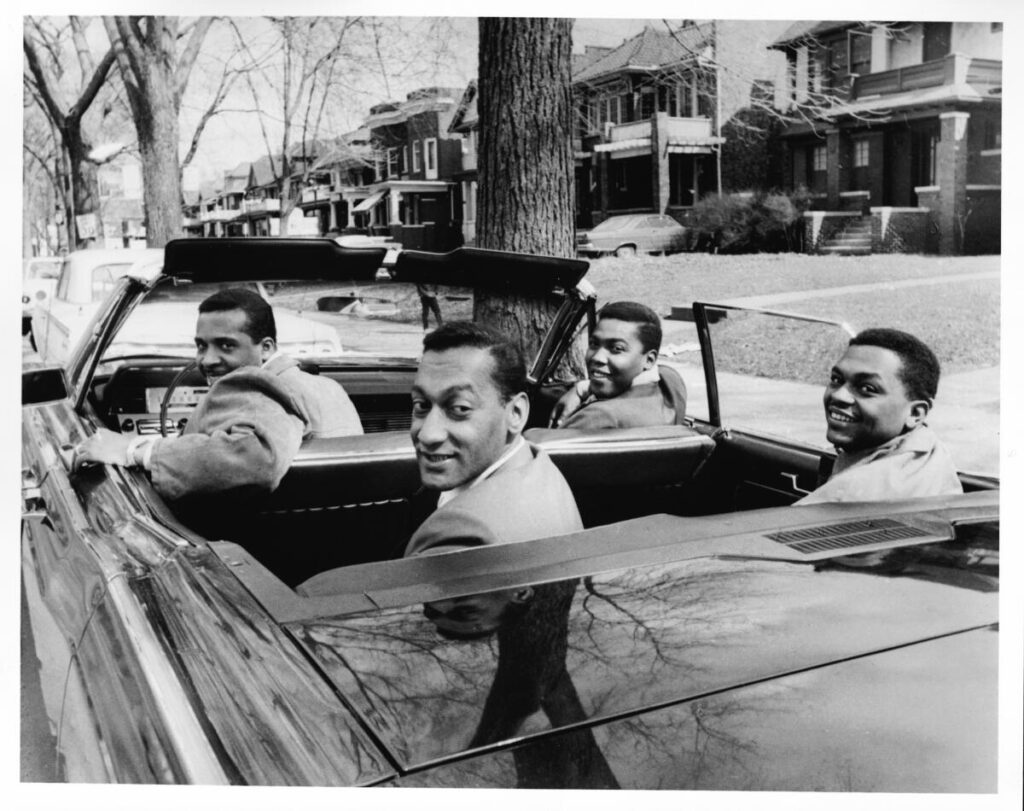 Four young men in a convertible car.