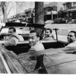 Four young men in a convertible car.