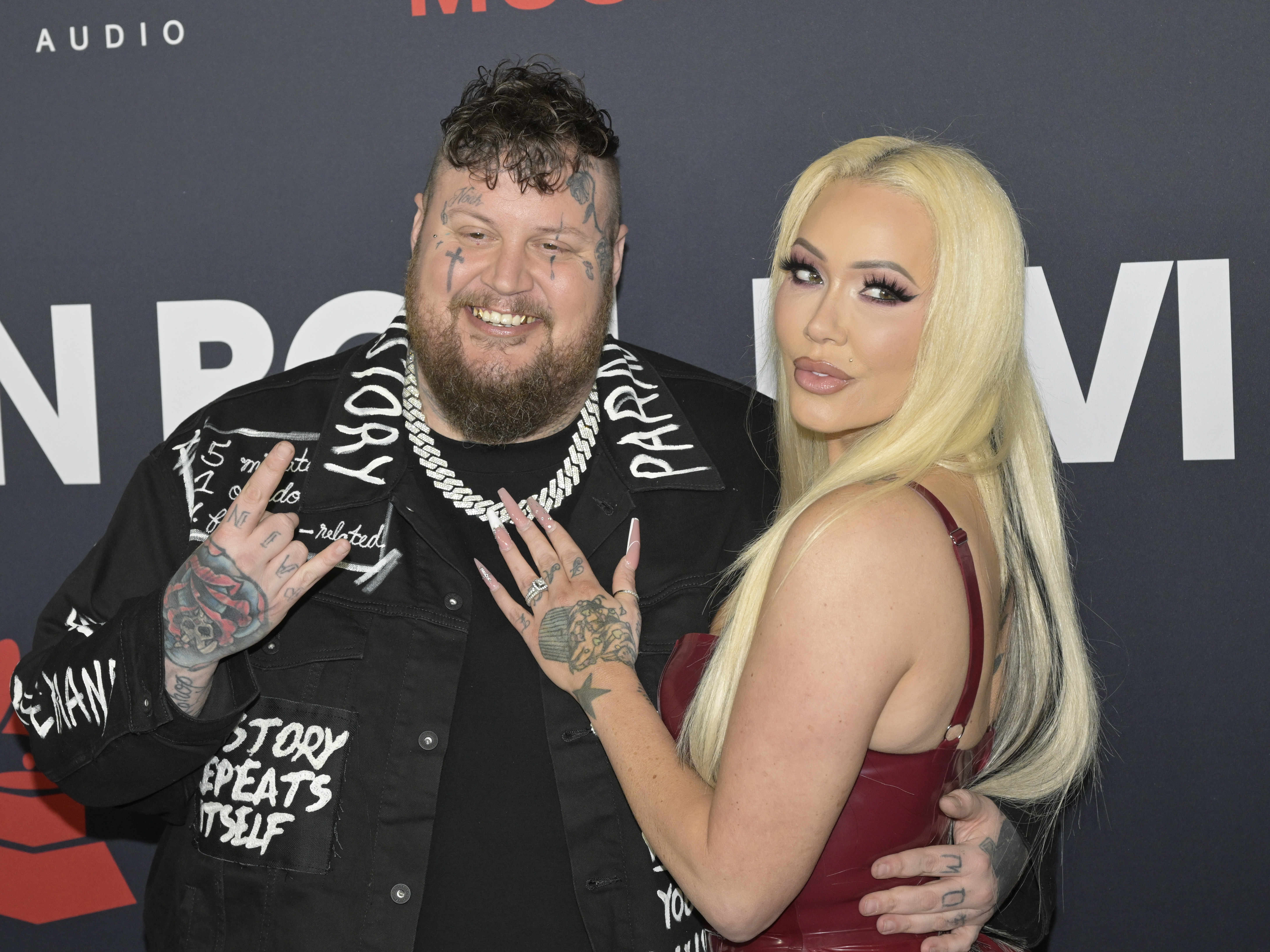 Jelly Roll and Bunnie Xo posing for photos at the 2024 MusiCares Person of the Year event in Los Angeles