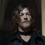 daryl dixon stands in a dark room in the walking dead season two book of carol