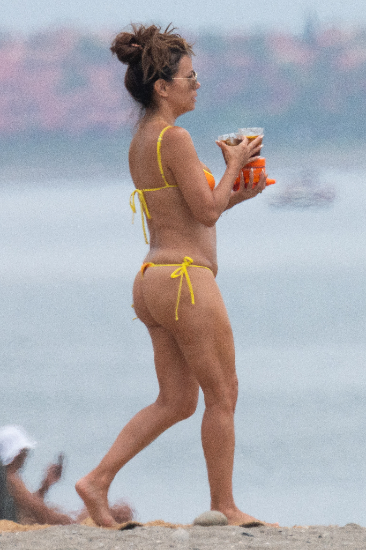 Eva Longoria wearing a multi-colored bikini while enjoying a summer day at the beach in Spain