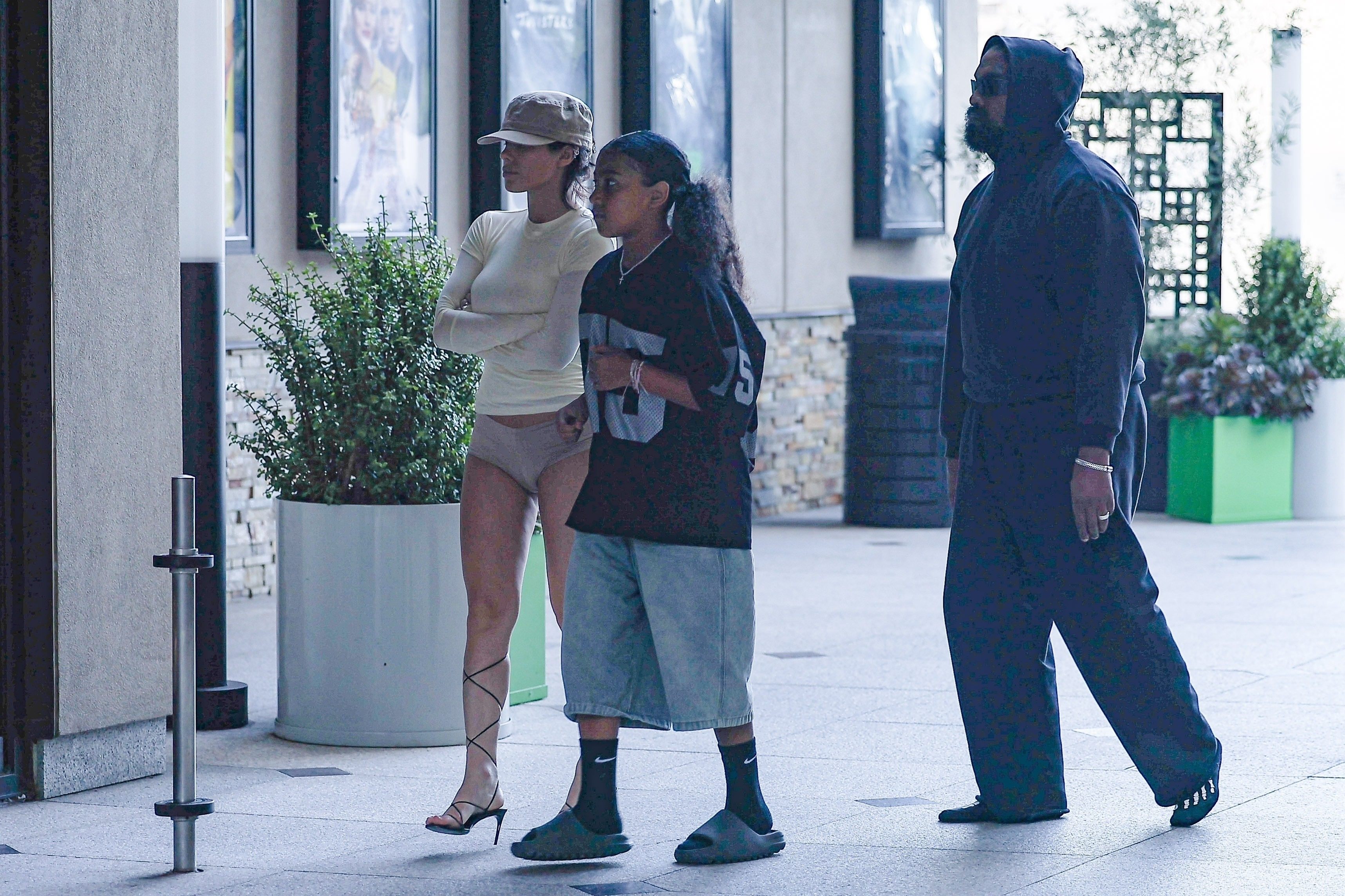 Bianca Censori, North West, and Kanye West heading into a movie theater to see Deadpool & Wolverine on Saturday in Los Angeles, California