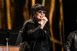 Ann Wilson, lead singer of rock band Heart, singing into a microphone during Farm Aid in Noblesville, Ind. in 2023