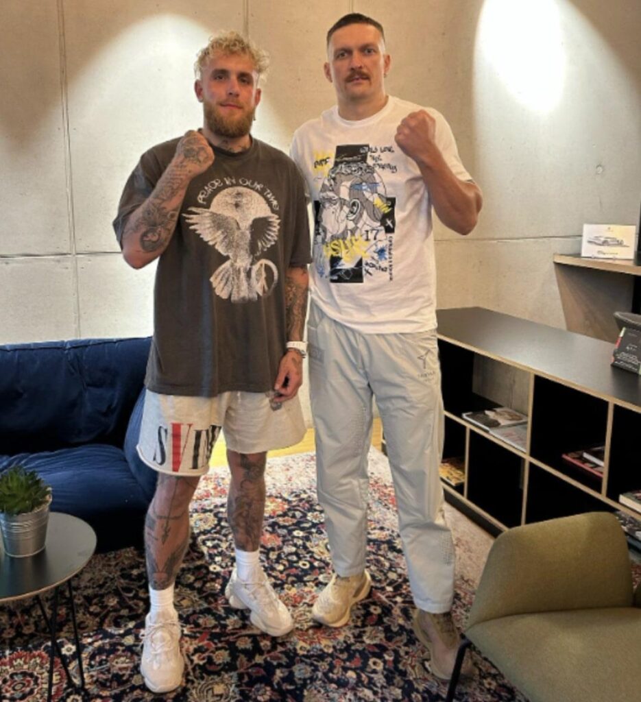 Jake Paul and Oleksandr Usyk meeting each other and raising fists