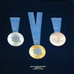 This photograph taken in Paris on February 8, 2024, shows the Olympic medals during the unveiling of the Olympic and Paralympic medals for the Paris 2024 Olympic Games. On the medals' head side, the engraved figures of the goddess of victory Athena, Nike, the Panathenaic stadium, and the Acropolis are imposed by the International Olympic Committee (IOC). Still, Paris 2024 has obtained exceptional authorization to add the design of the Eiffel Tower and use 18 grams of Eiffel Tower metal on each medal, extracted from pieces of the tower. (Photo by Dimitar DILKOFF / AFP) (Photo by DIMITAR DILKOFF/AFP via Getty Images)