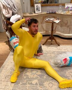 Luke Bryan posing on the floor in a skintight yellow bodysuit in a birthday post shared by his wife Caroline Bryan