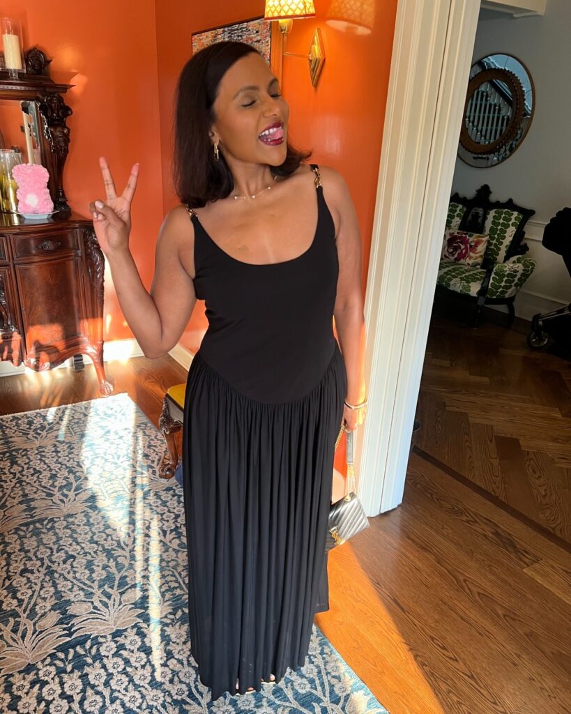 The Office star Mindy Kaling posing in a black summer dress while holding up the peace sign for a new Instagram carousel