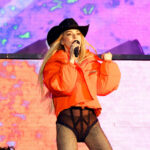 Shania Twain performs at the Lytham Festival in an orange puffer jacket with a western hat