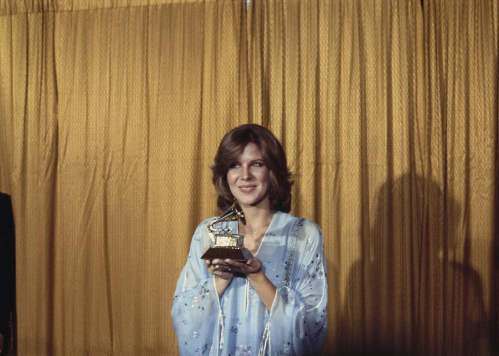 Debby Boone holding the best new artist trophy during the 20th Anniversary Grammy Awards.