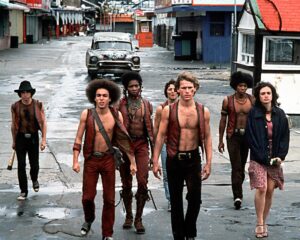 Shirtless gang members in vests walk the streets of New York in "The Warriors."