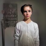 Elizabeth Taylor as a child in a white, long-sleeve top.