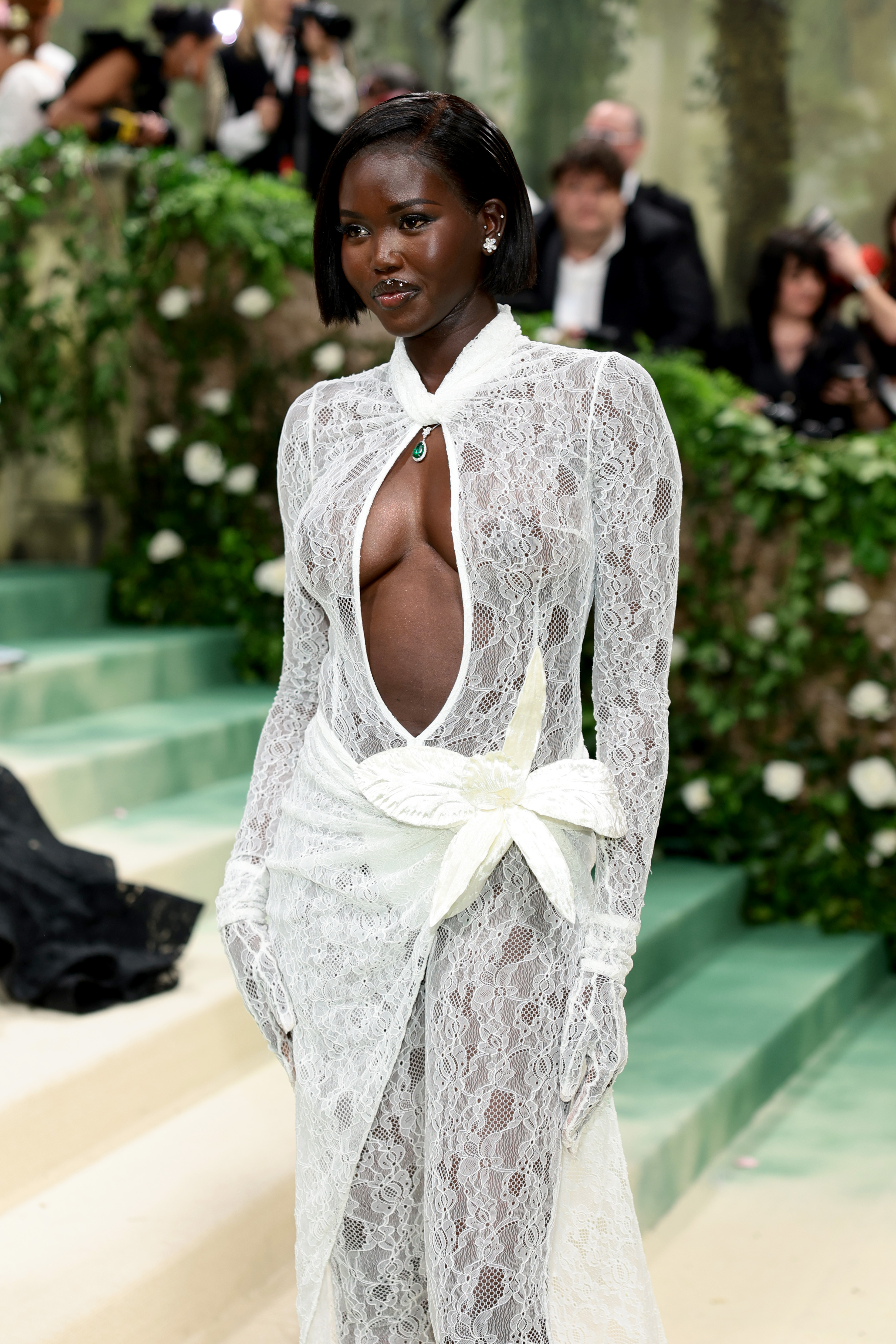 Adut Akech attends The Met Gala in a lacy white dress at The Metropolitan Museum of Art on May 6