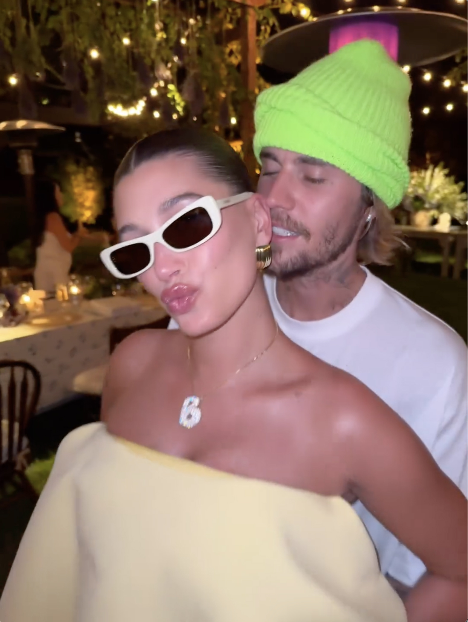 Hailey Bieber poses for the camera as her husband, Justin Bieber, embraces her