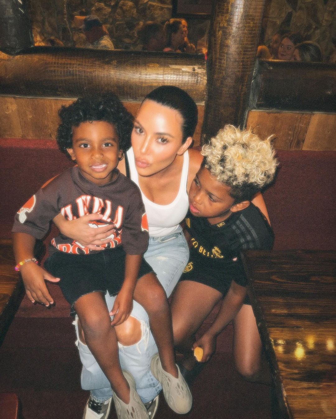 Kim Kardashian cuddling with her sons Psalm and Saint over summer break