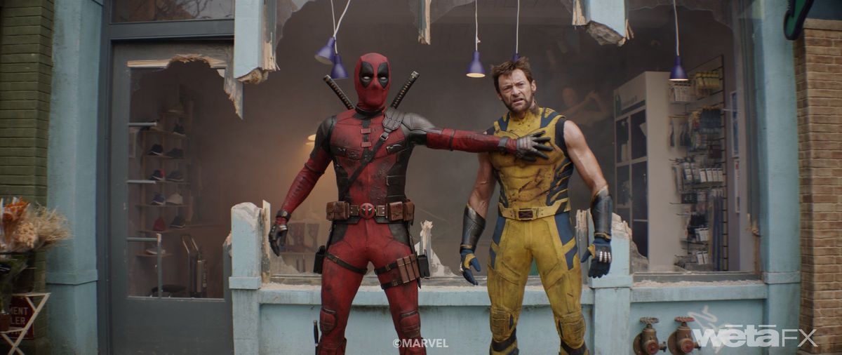 Deadpool (Ryan Reynolds) and Wolverine (Hugh Jackman) stand together in front of a blown-out store front in Deadpool & Wolverine