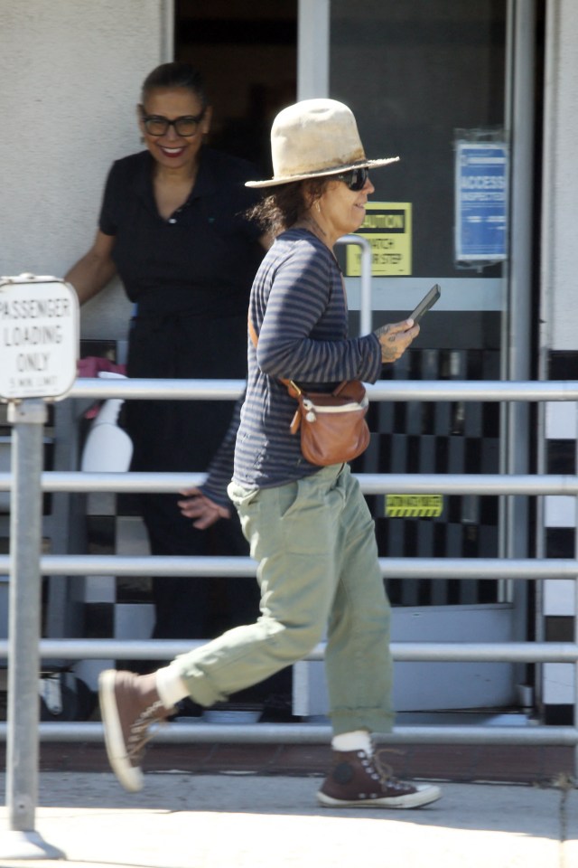 She completed her look with a pair of dark Converse hi-tops and a cross-body bag, as Linda Perry was seen talking on the phone