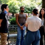 Director Hiro Murai talks with actors Donald Glover and Maya Erskine and a woman with her back to the camera.